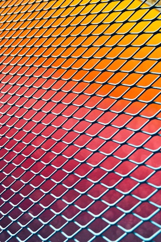 Realistic image of freshly made orange and gray chain link fences stacked neatly.