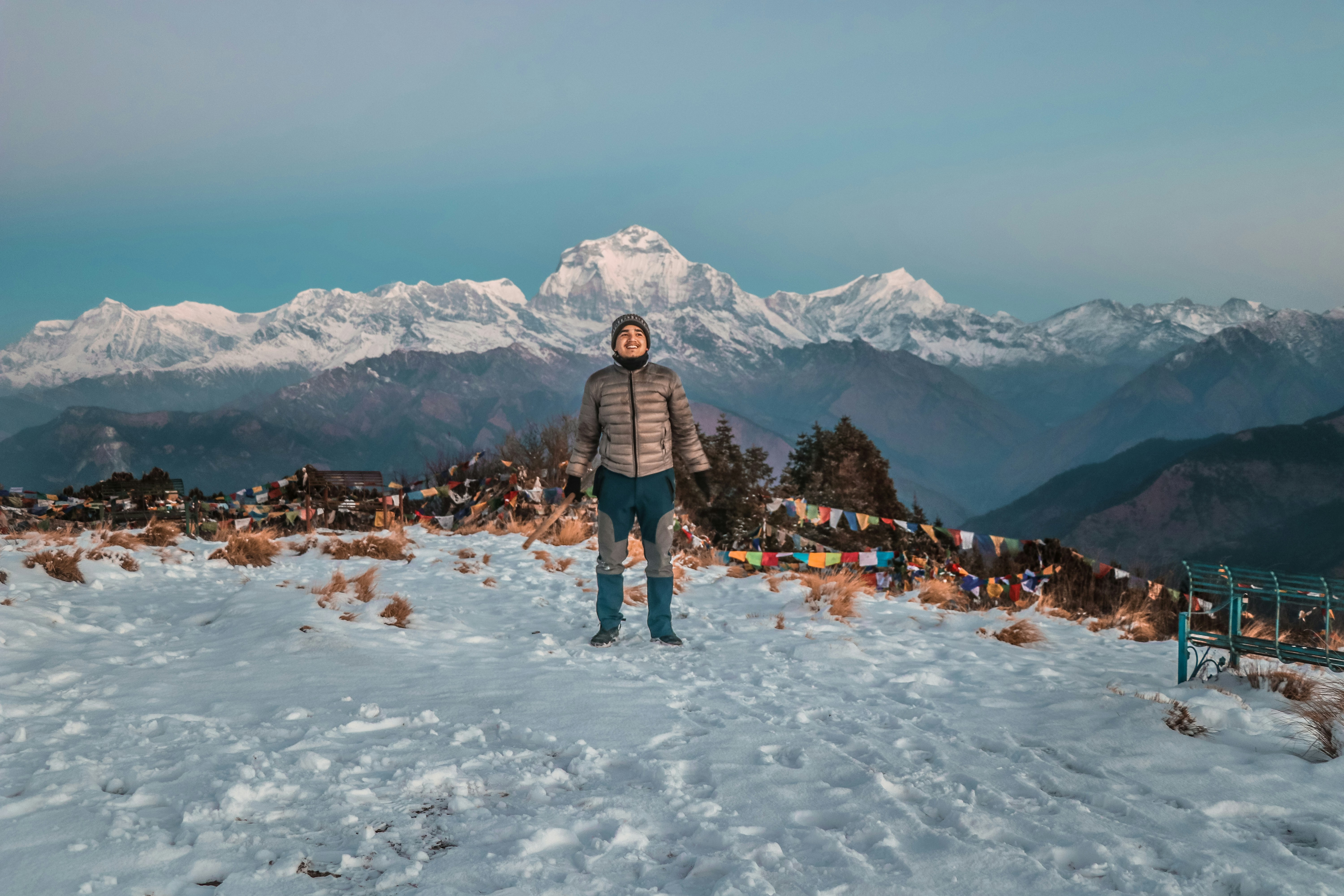 Pemba Sherpa, Himalayan expedition guide, standing at high altitude with prayer flags
