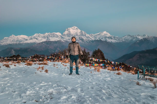 A warm local guide smiling against the backdrop of Tawang's misty mountains.