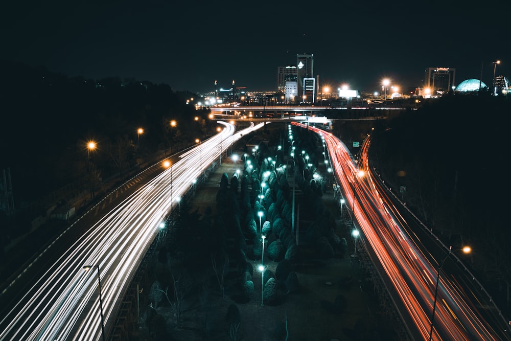 luzes brancas e vermelhas passando nas estradas à noite