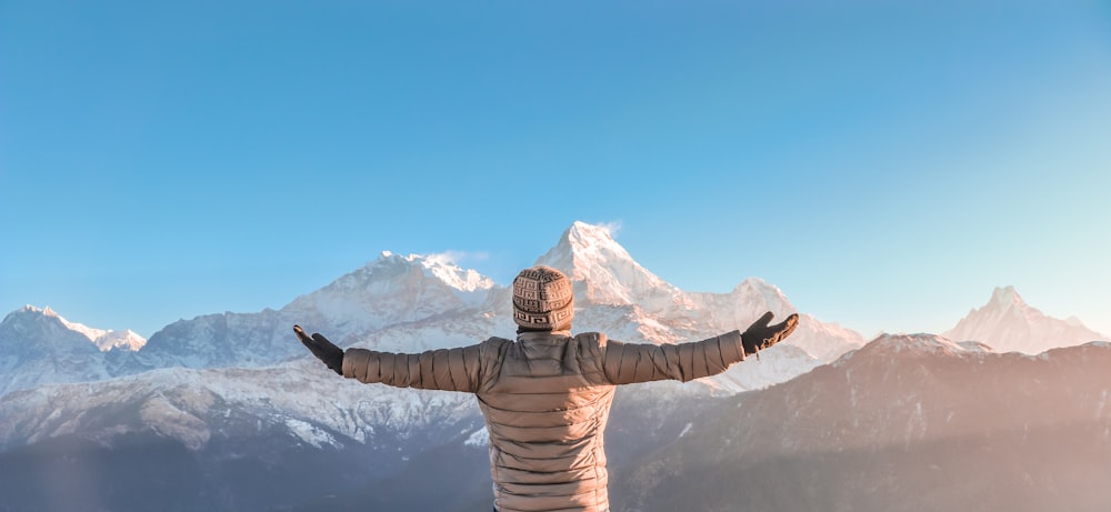 person spreading arms on mountain