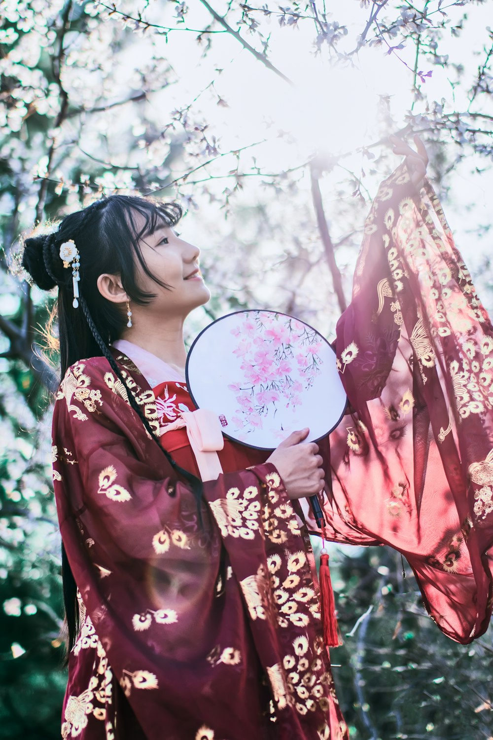 woman wearing maroon floral dress near trees