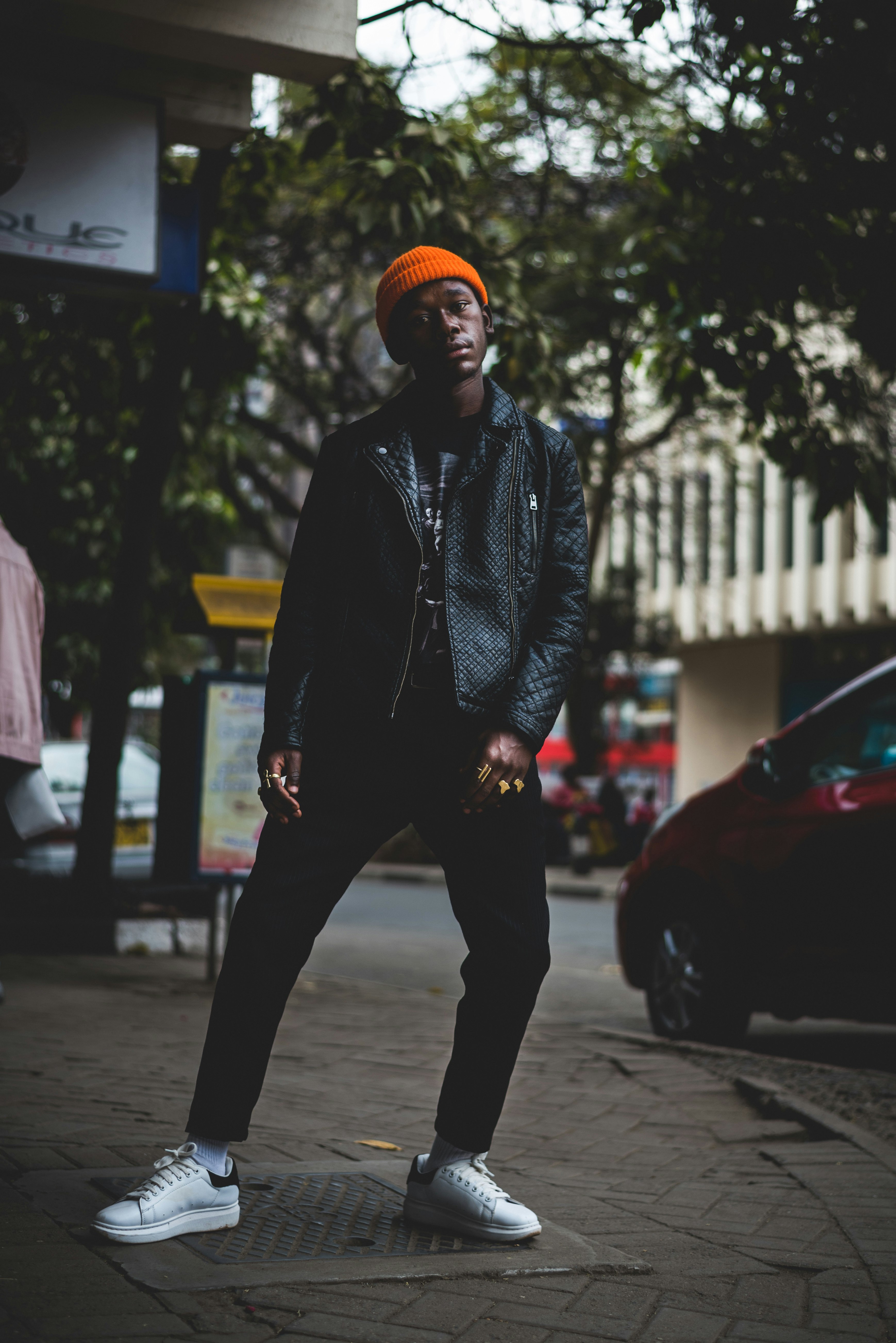 man in black jacket standing beside road