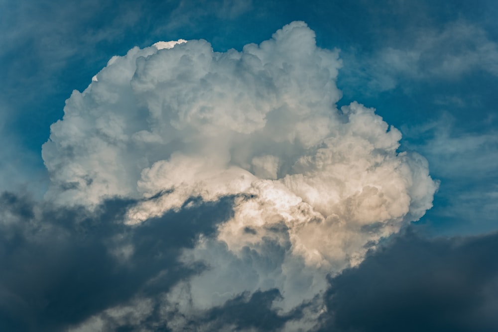 a very large cloud in the sky with a blue sky behind it