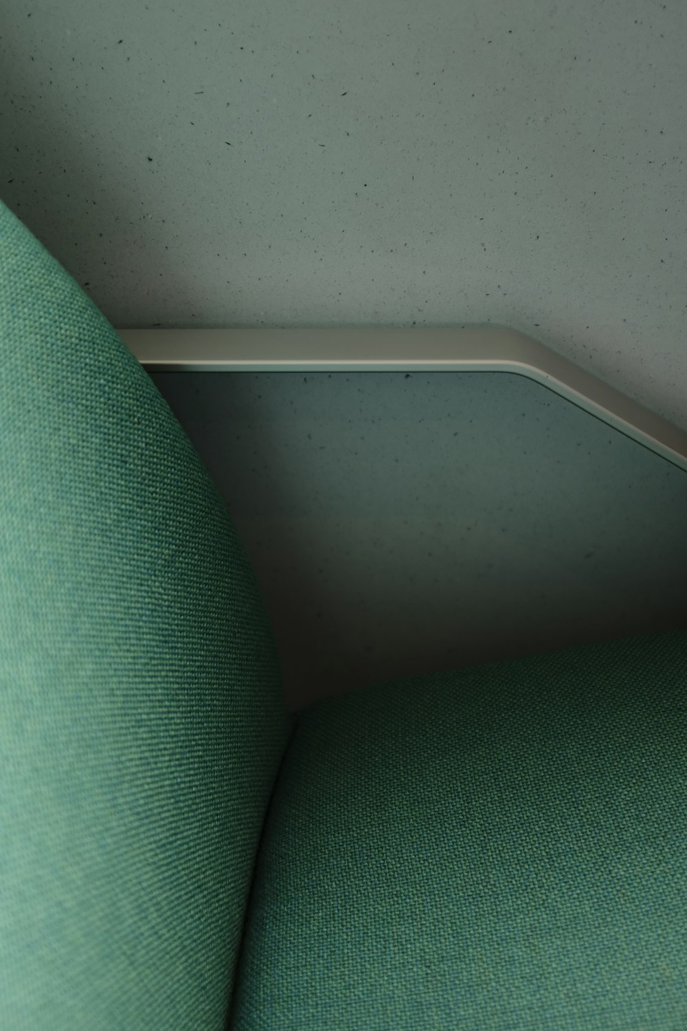 a close up of a green chair with a metal edge