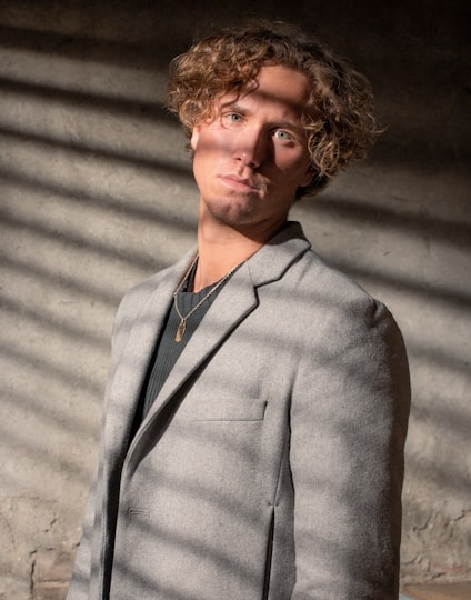 man wearing gray notched lapel suit jacket standing