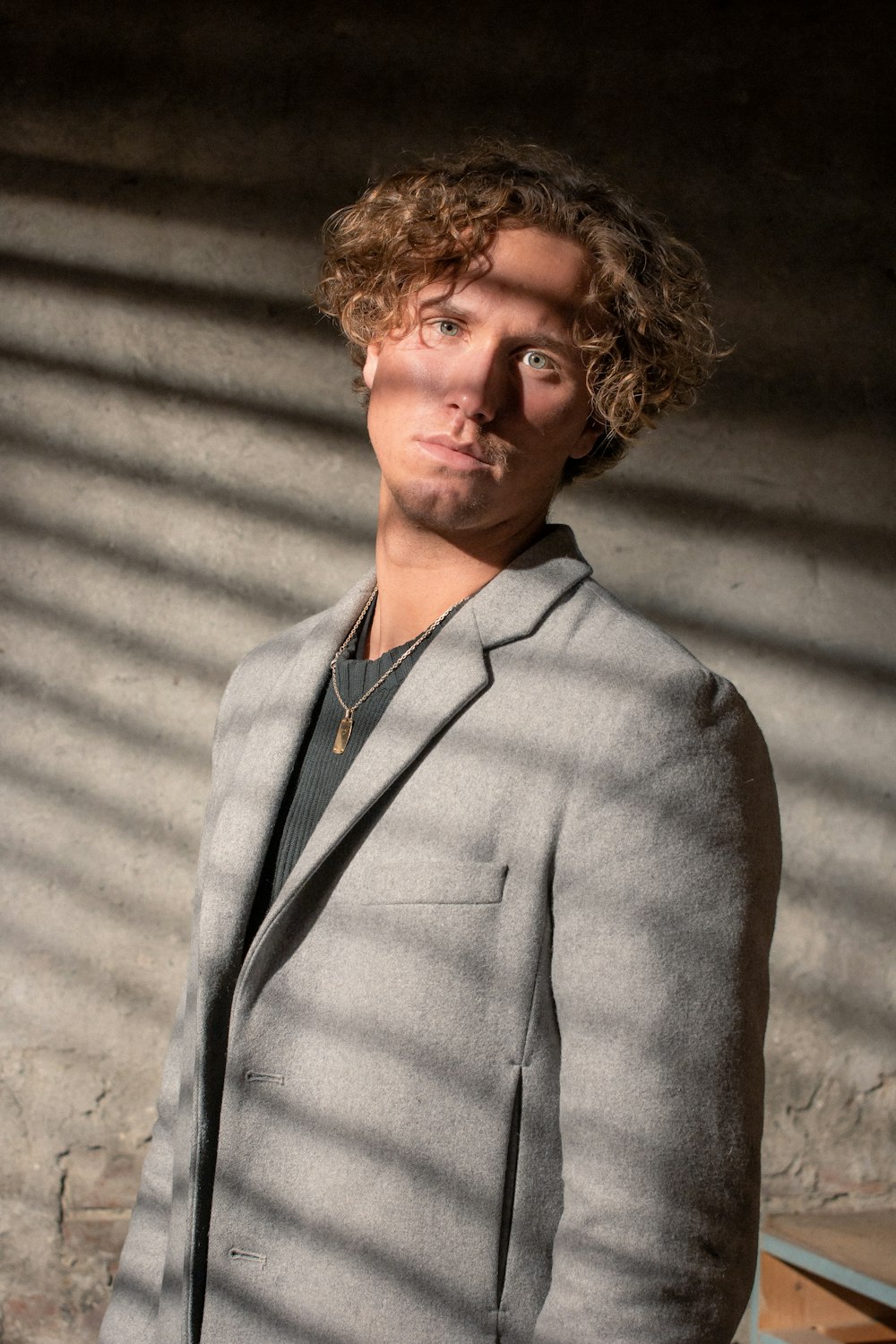 homme portant une veste de costume à revers cranté gris debout