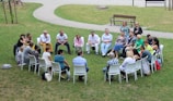 circle of people sitting on chair on grass fiedl
