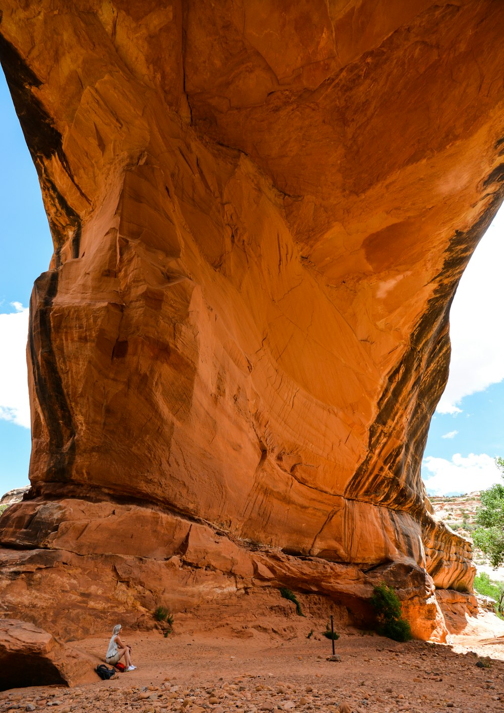 person sitting near brown rock formation