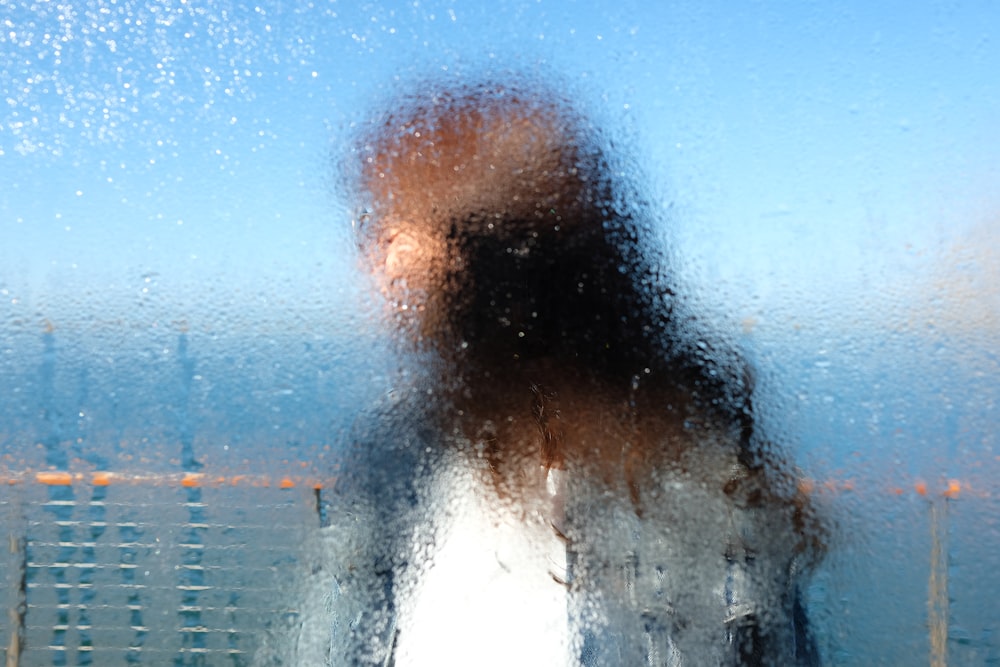 Una foto sfocata di una persona in piedi davanti a una finestra