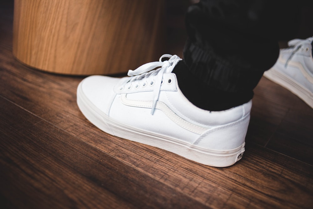 person wearing white Vans OldSkool low-top sneaker