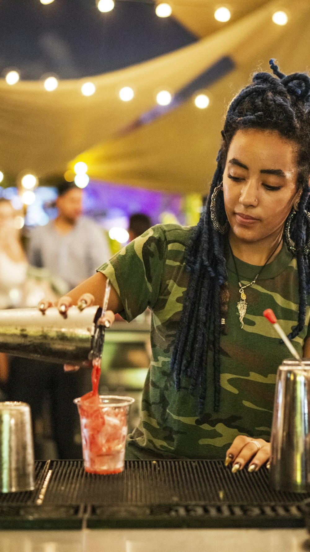 woman pouring beverage on plastic cup