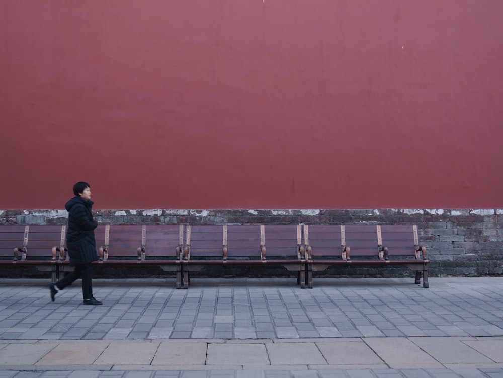 woman walking beside bench