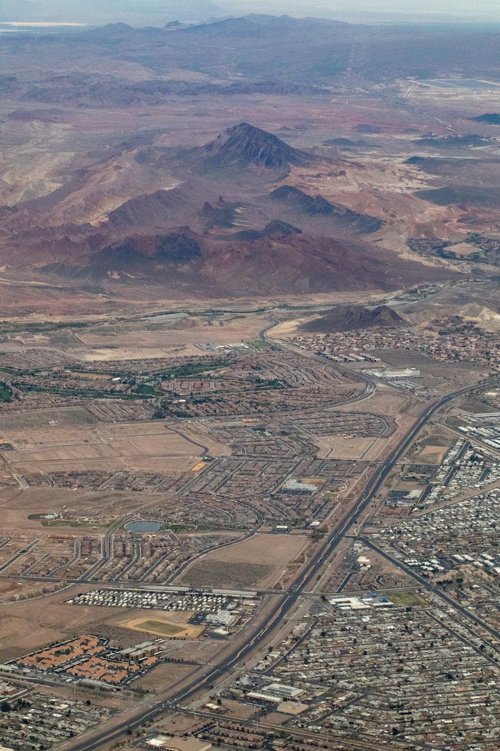 an aerial view of a city with mountains in the background