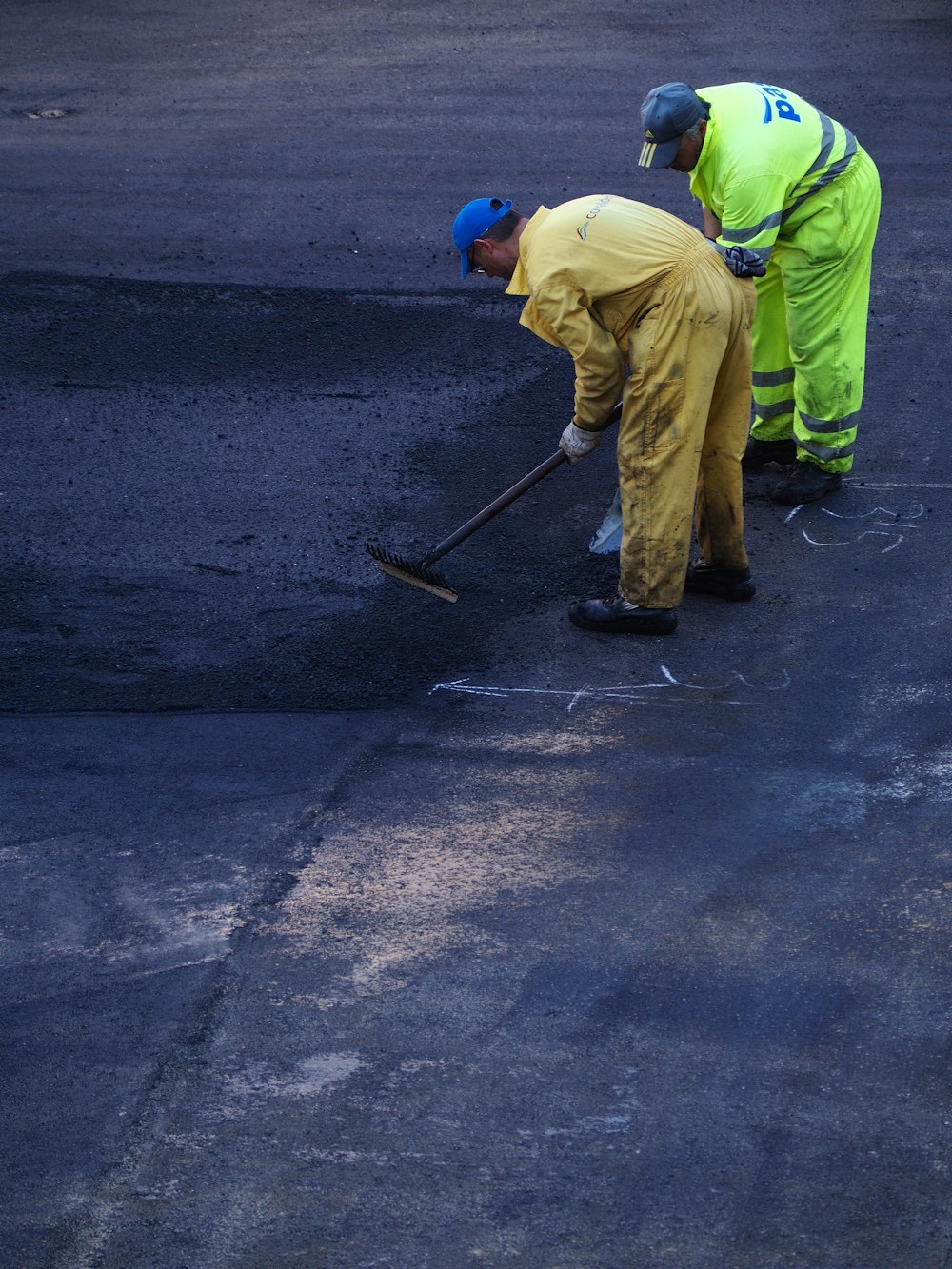 two man construct road during daytime