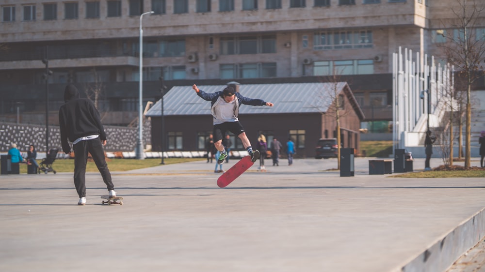 a man riding a skateboard next to another man on a skateboard