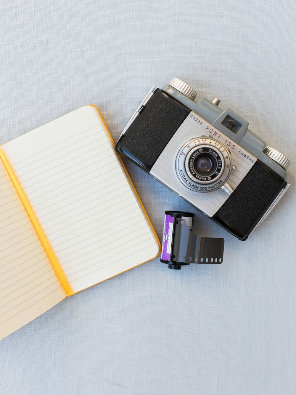 a camera and a notebook on a table