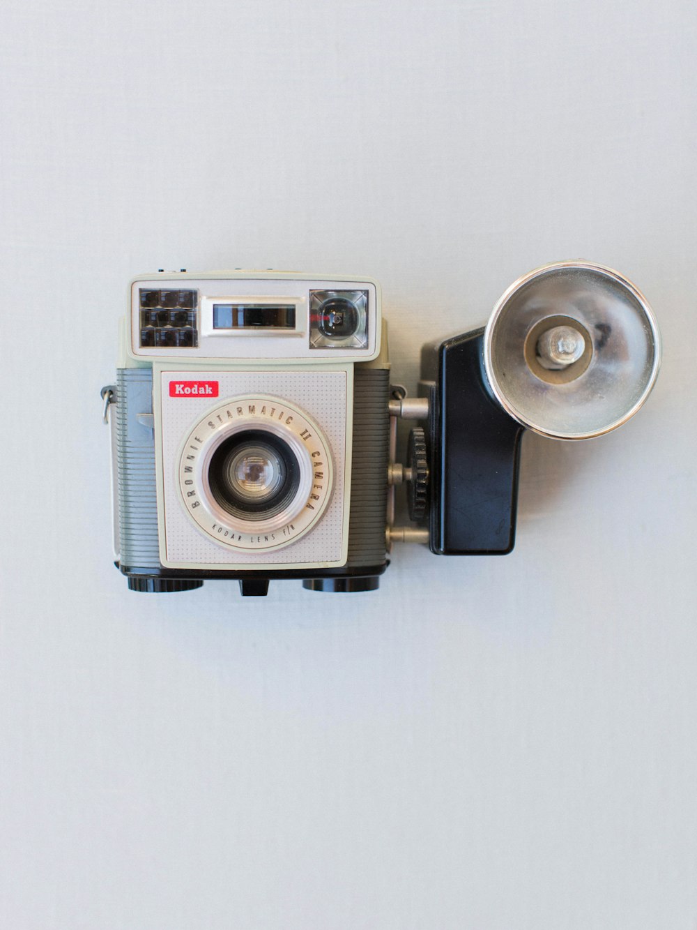 white and gray vintage camera on white surface