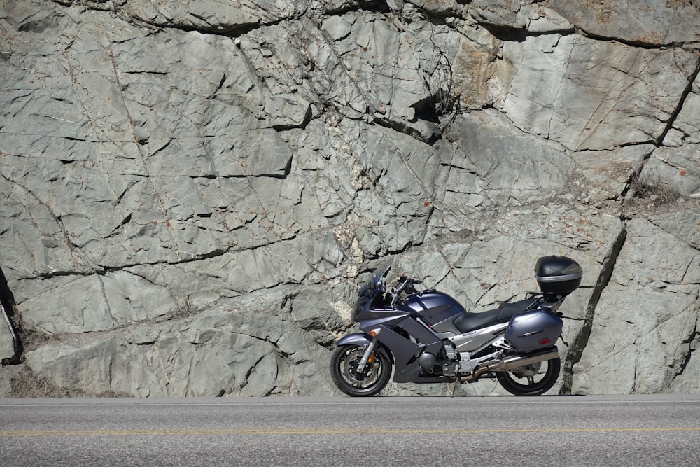Parc de motos sport gris près d’un mur de pierre