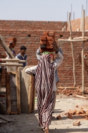 woman carrying bricks on her head