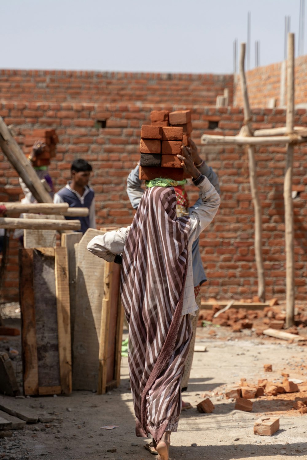 woman carrying bricks on her head