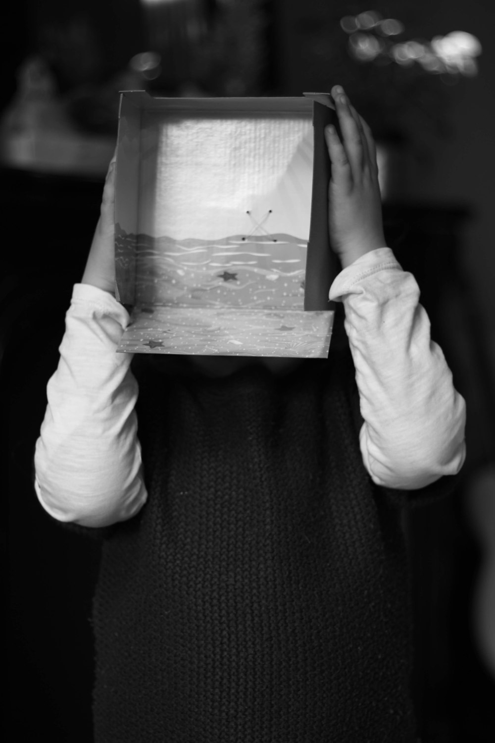 person holding box covering his face