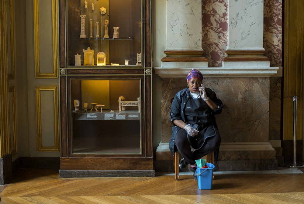 woman in black jacket sitting on brown wooden chair