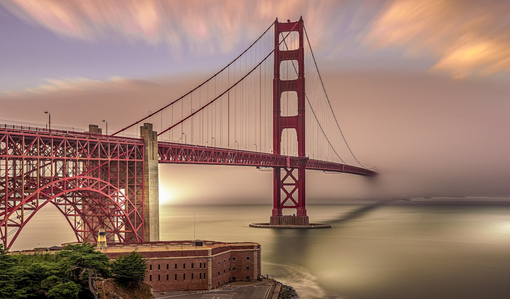 landscape photography of red suspension bridge