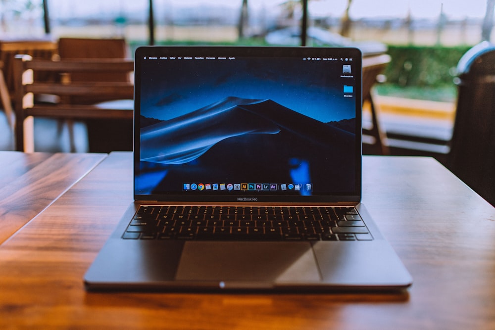 MacBook Pro sobre superficie de madera marrón