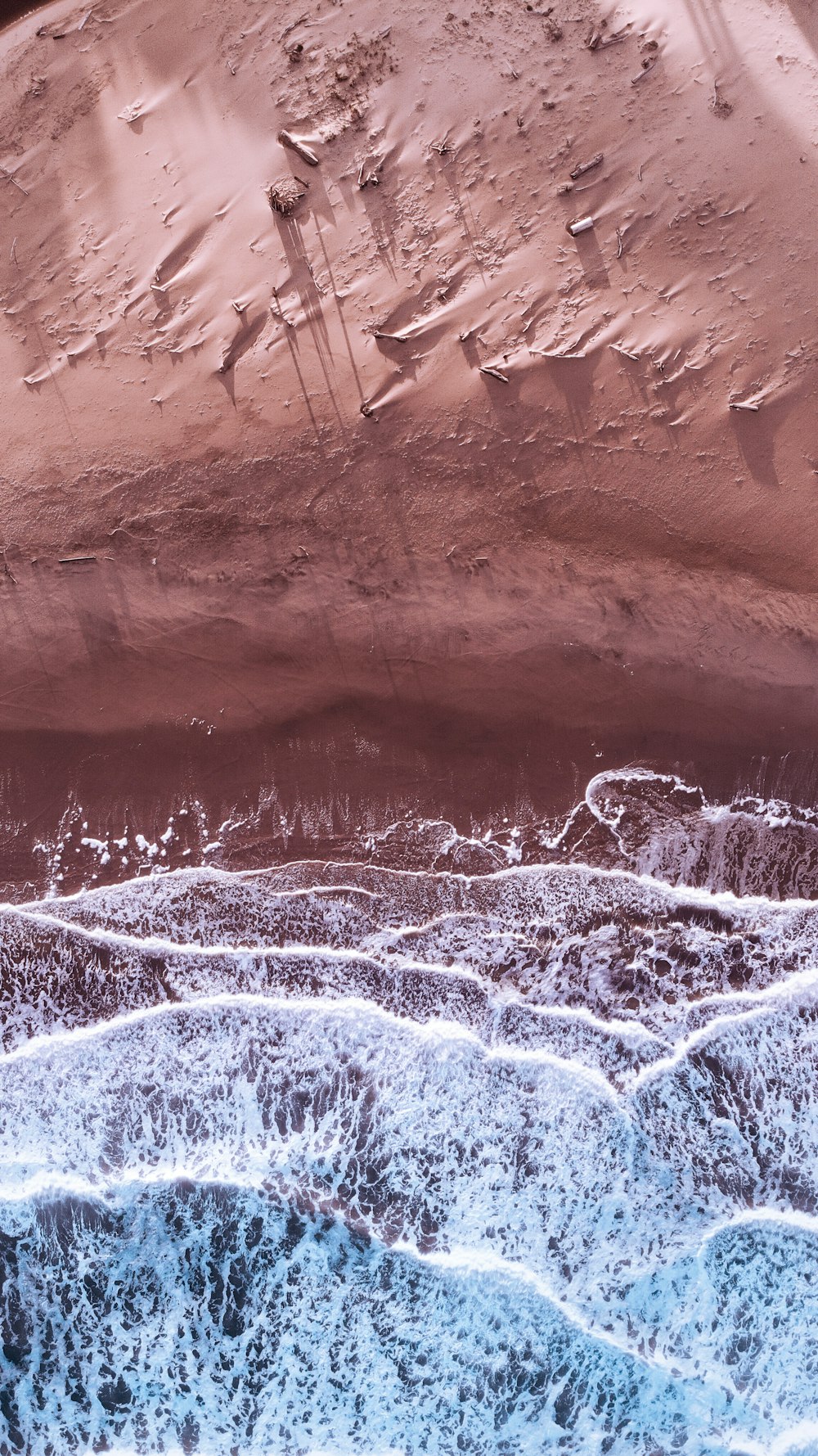 an aerial view of a sandy beach and ocean