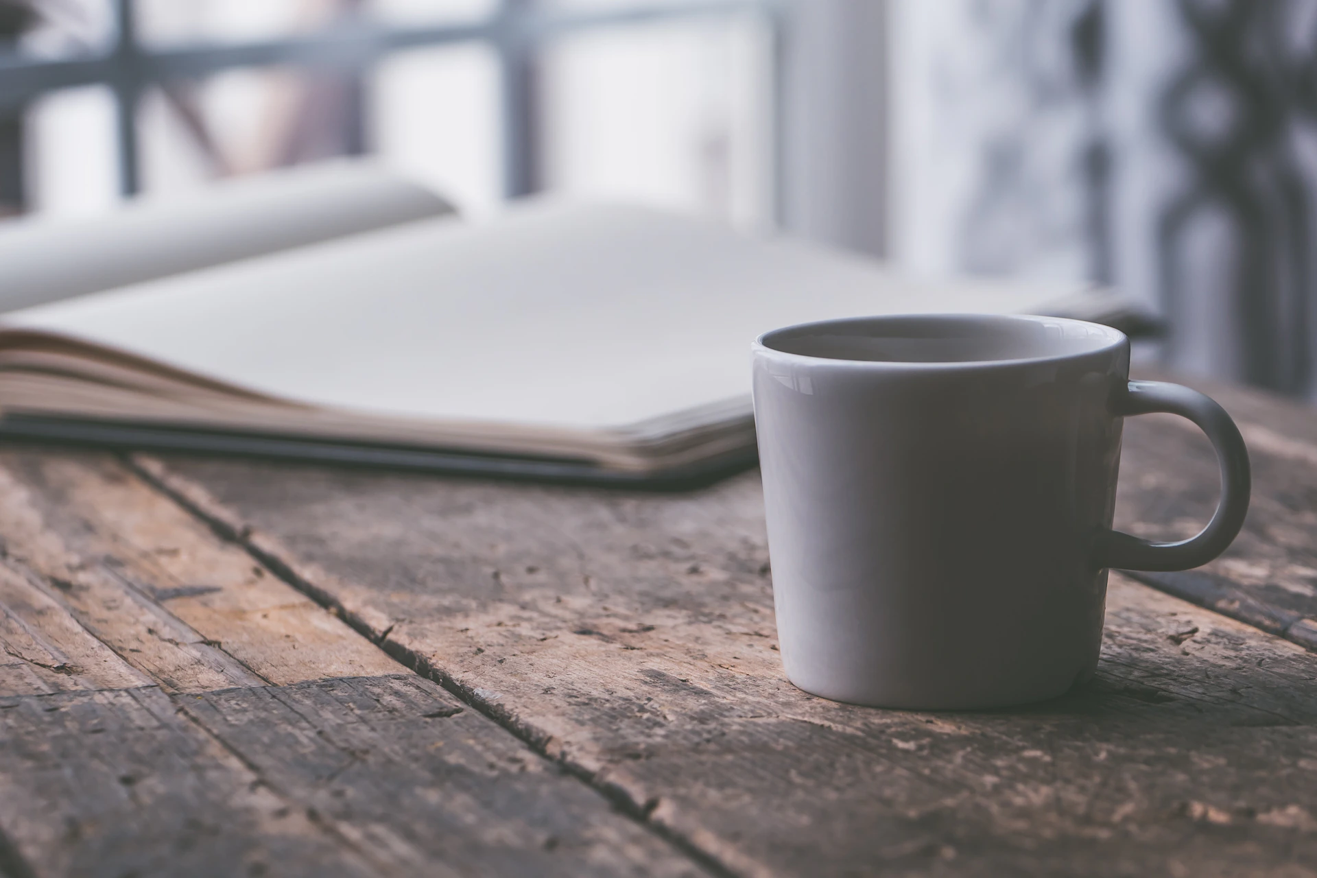 white ceramic mug on brown table