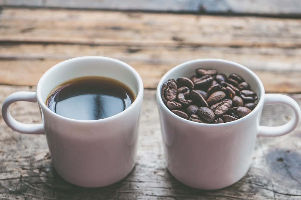 two white ceramic mugs on brown wooden surface