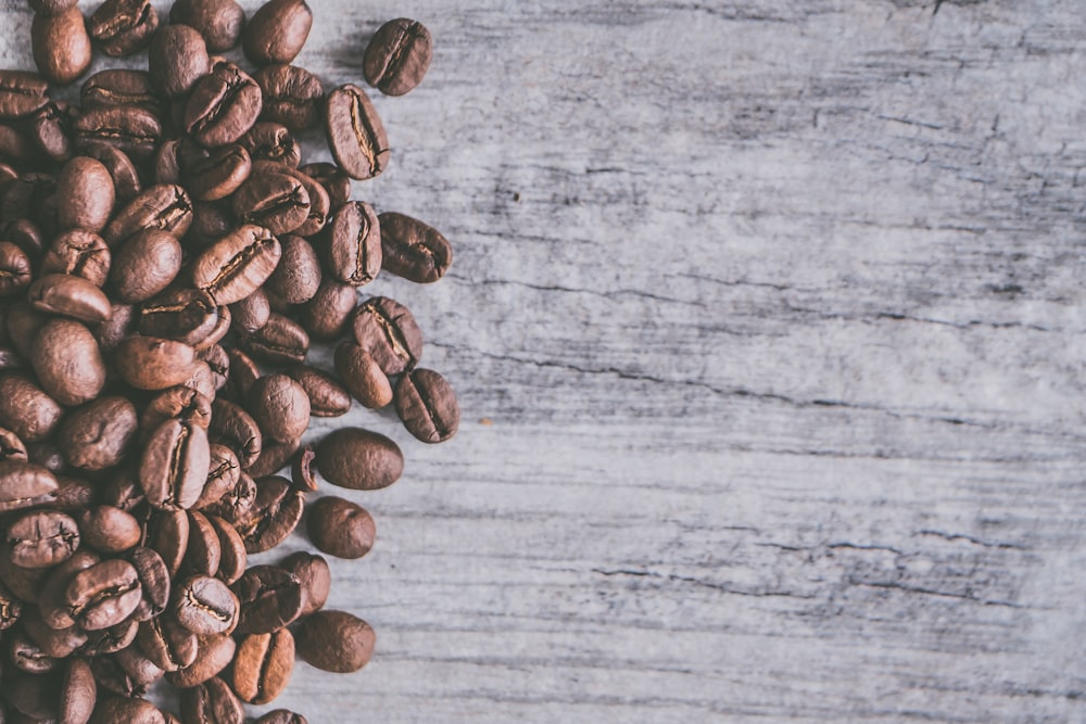 a pile of coffee beans sitting on top of a wooden table