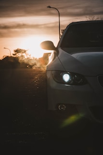 A sleek Maruti Suzuki car parked by a scenic roadside at sunrise, ready for a morning journey.