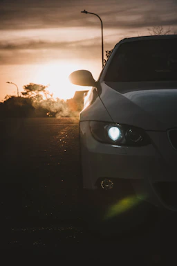 A sleek 2025 Camry taxi parked by a Kuwaiti street at sunset.