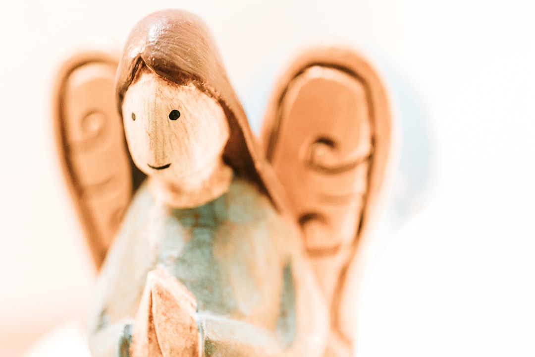 selective focus photography of brown angel figurine