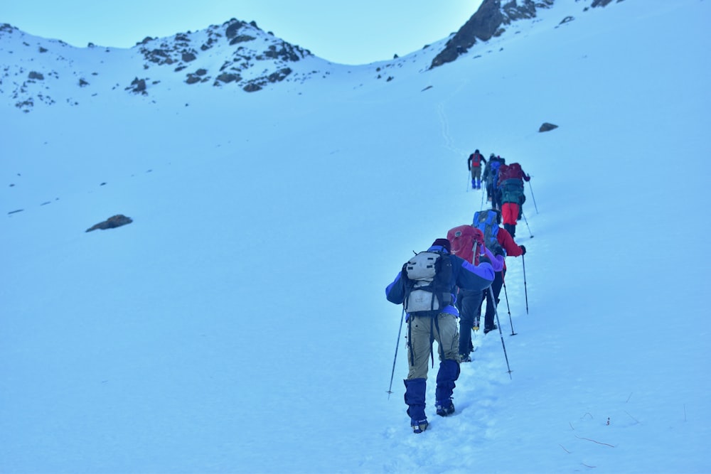 people climbing snow covered mountain during daytime