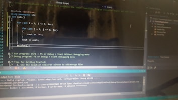 A computer screen displaying a code editor with a C++ program. The code includes a main function and nested for loops for printing stars. There are various sections of the interface visible, including a text editor with syntax highlighting, output panel showing build results, and project explorer on the side.