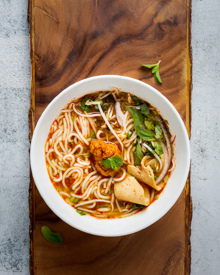 Steaming Vietnamese noodle soup with herbs and chopsticks