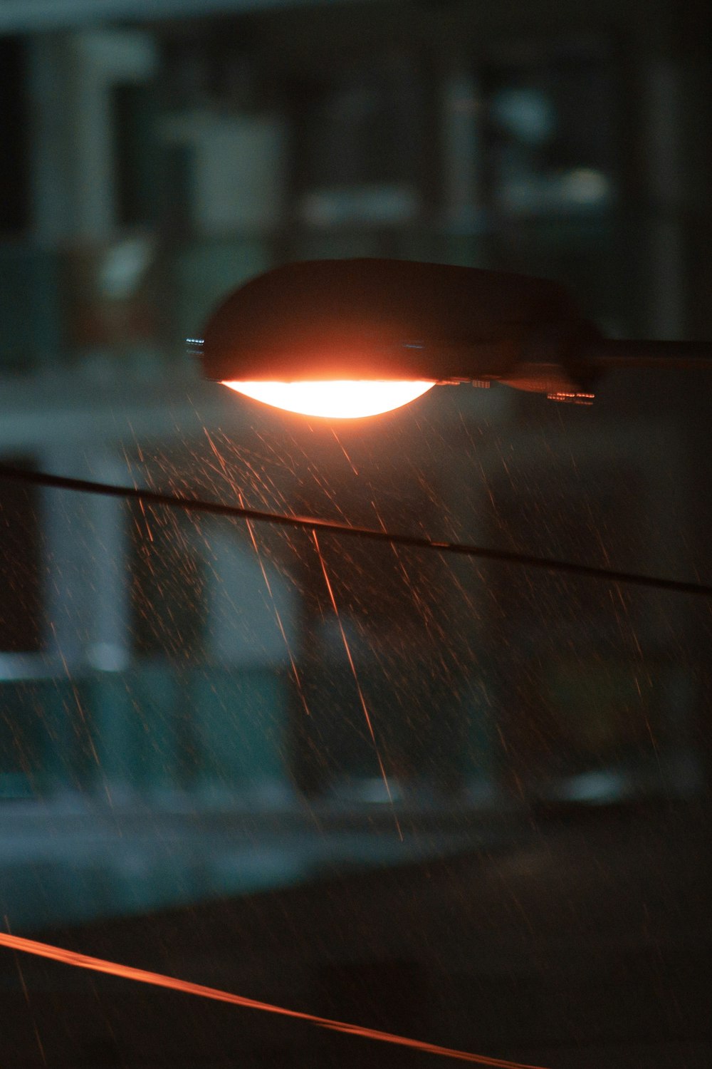 turned-on light post under the rain