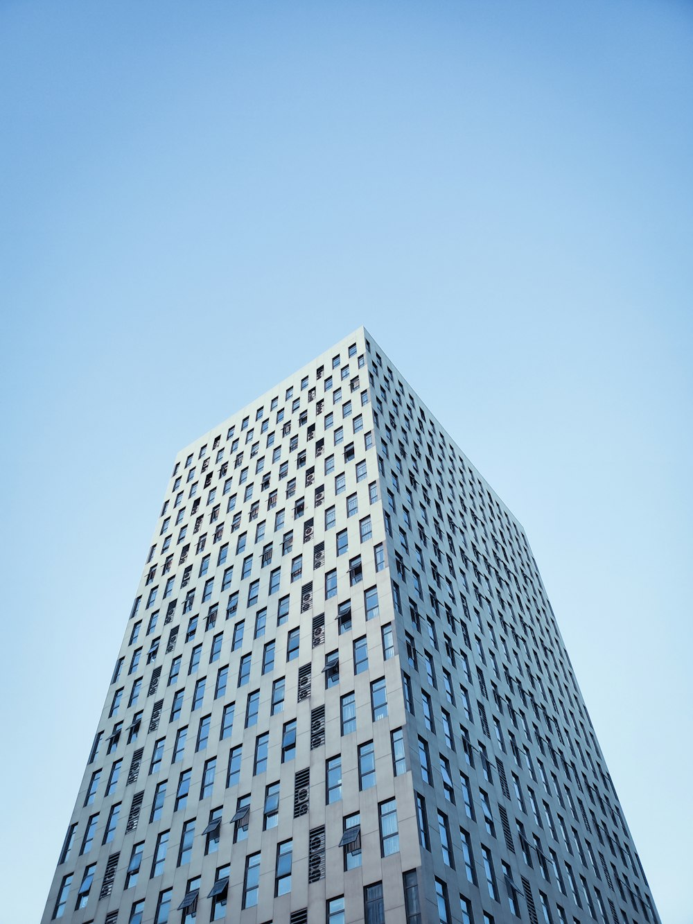 Photographie en contre-plongée d’un immeuble de grande hauteur sous un ciel bleu clair