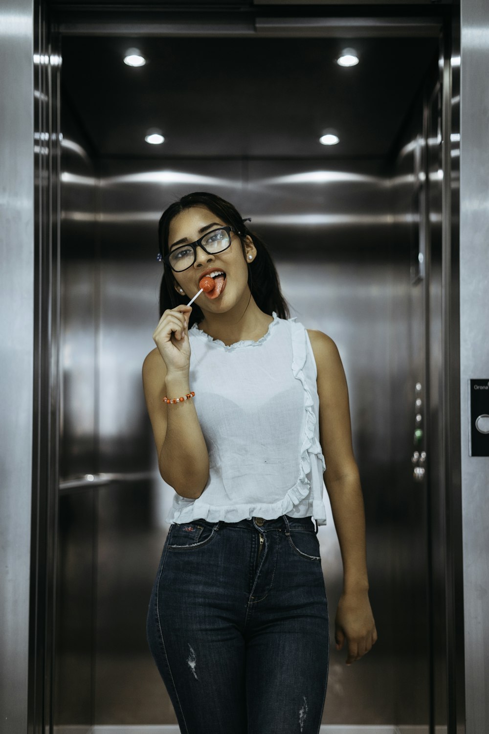 Mujer comiendo piruleta en el ascensor