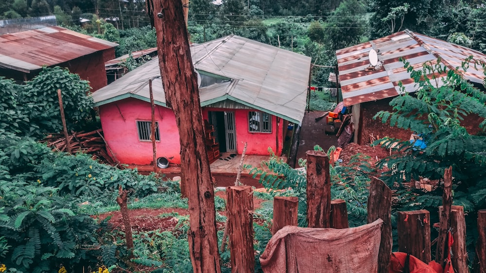 a red house surrounded by trees and bushes