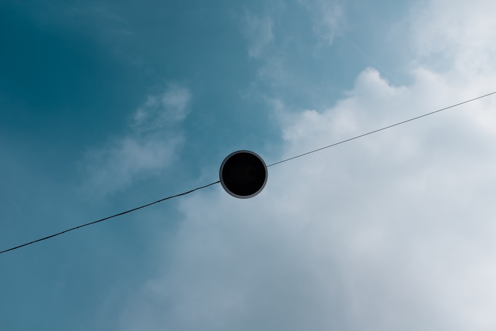 a round object hanging from a wire in the sky