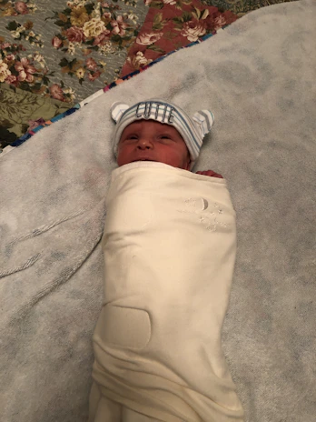 A personalized baby blanket with a name embroidered on it.