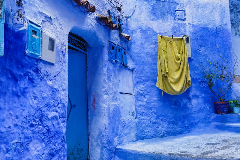 a blue building with a yellow curtain hanging from it's side