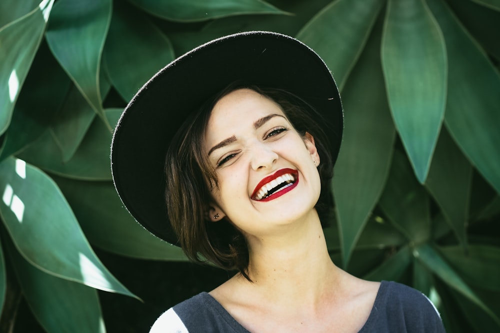 smiling woman standing beside plant