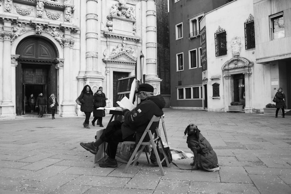 man sitting on chair near dog