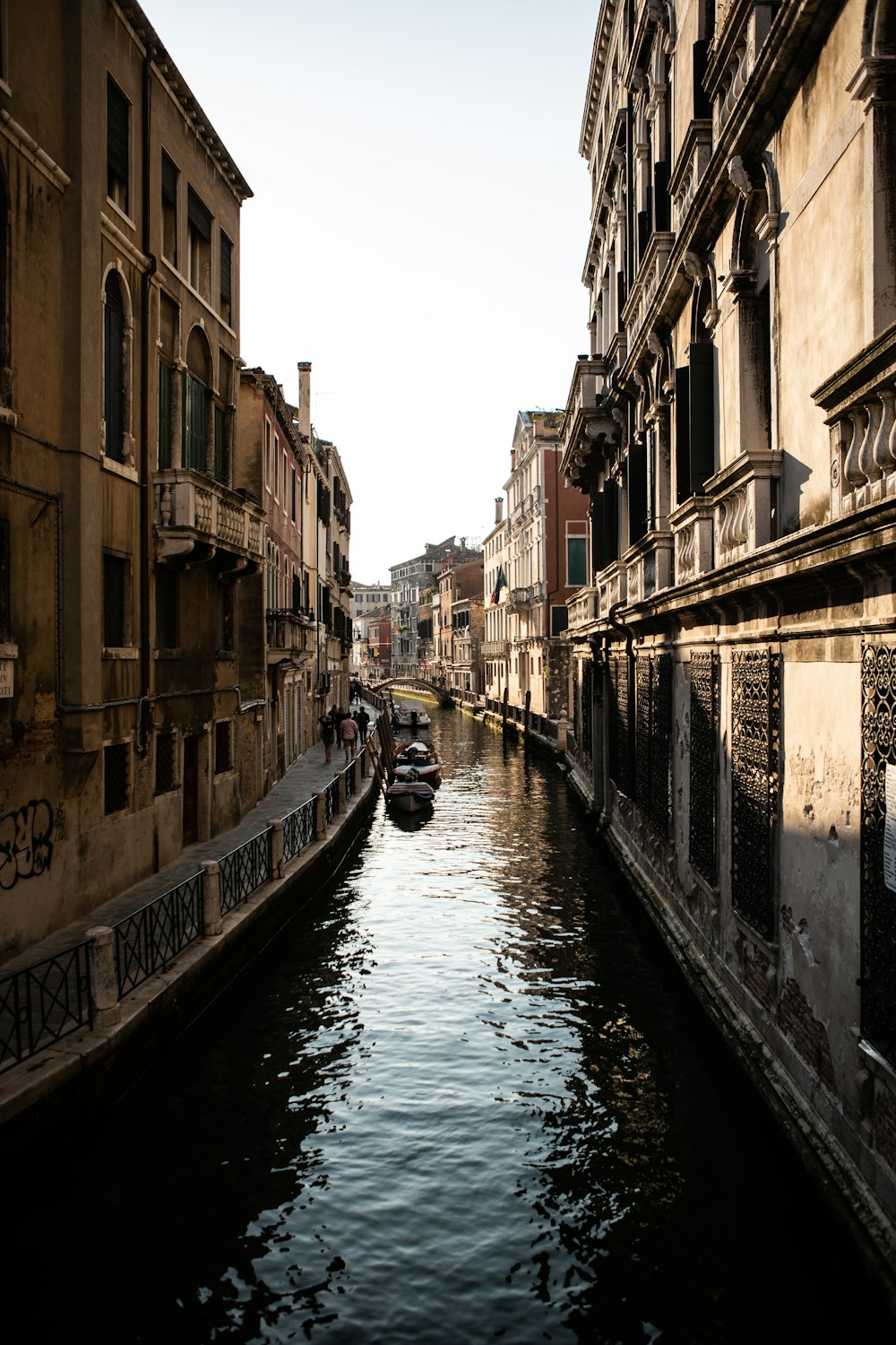 brown boat on body of water between brown houses