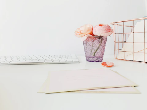 Minimalist workspace with pink and white tones featuring pipe cleaner craft tools and materials.